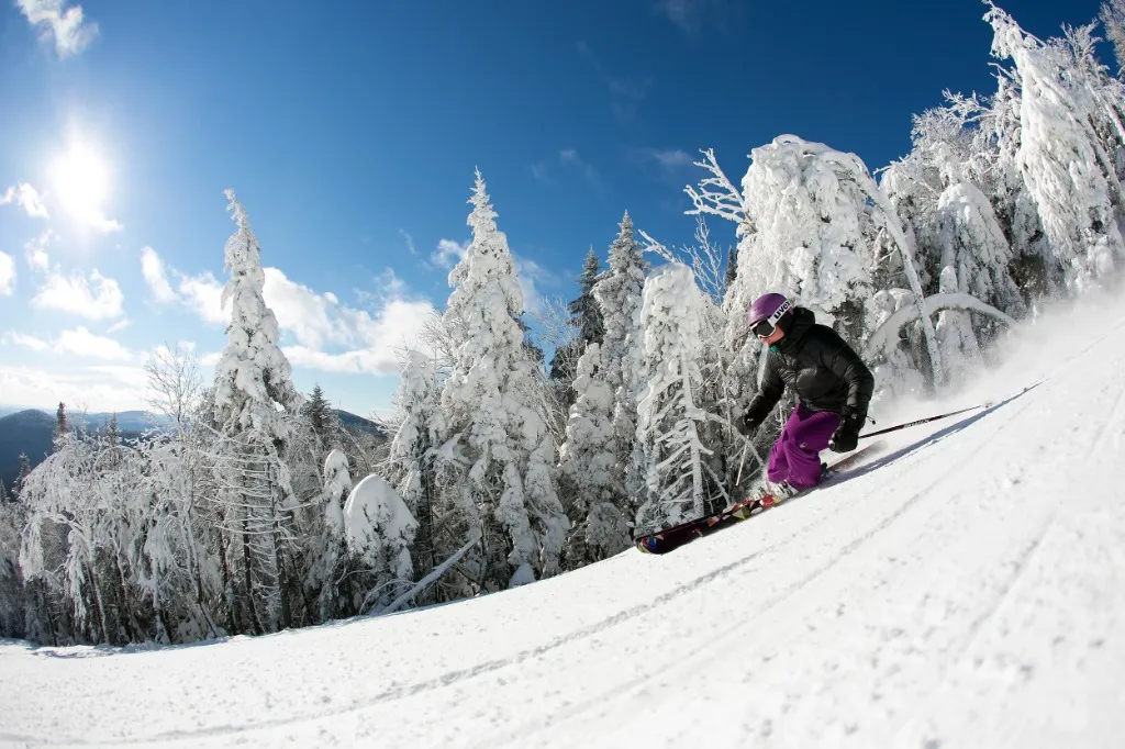 Skier carving down a snowy slope at Killington Resort